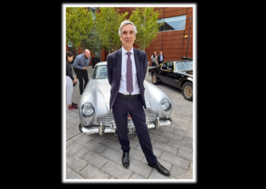 John in front of a bond car